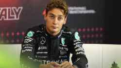 George Russell of Mercedes F1 sitting in a press conference wearing race suit