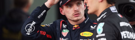 Max Verstappen looks at George Russell wearing their respective team race suits