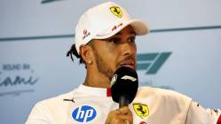 Hamilton in white Ferrari team attire speaking