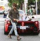 Hamilton walking beside a red Ferrari.
