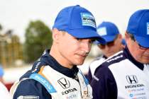 Racing driver in team uniform, cap.