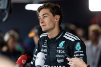 George Russell, Formula One driver in team uniform with microphones giving a press conference