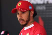 Ferrari cap, red team uniform, focused.