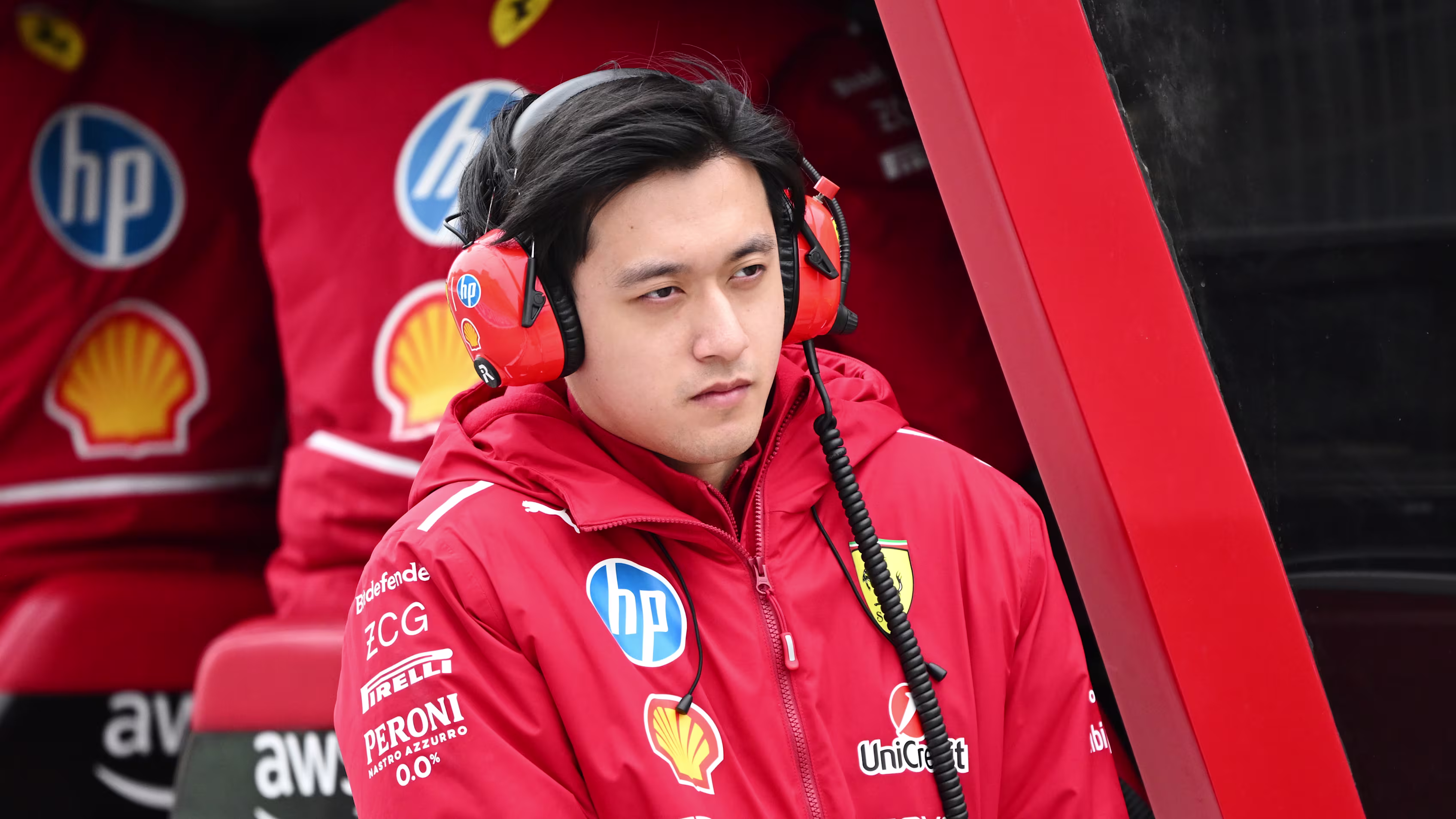 Zhou Guanyu for Ferrari team in red uniform.